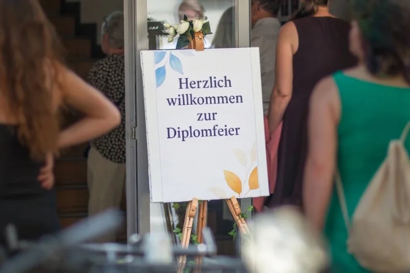 Eingang zur Veranstaltung mit Flipchart Herzlich willkommen